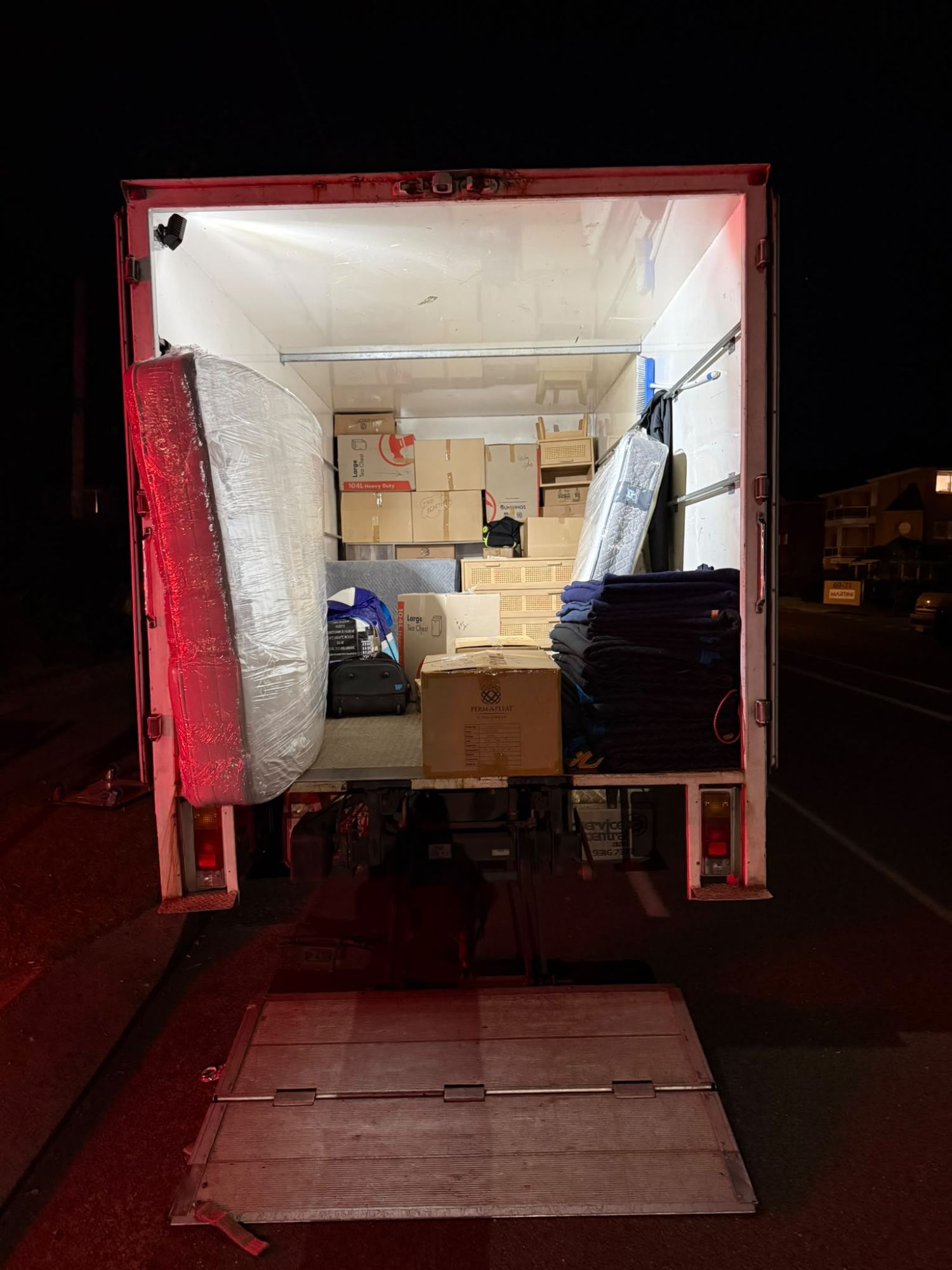 Mooove Removals truck loaded with boxes and mattresses at night in Sydney