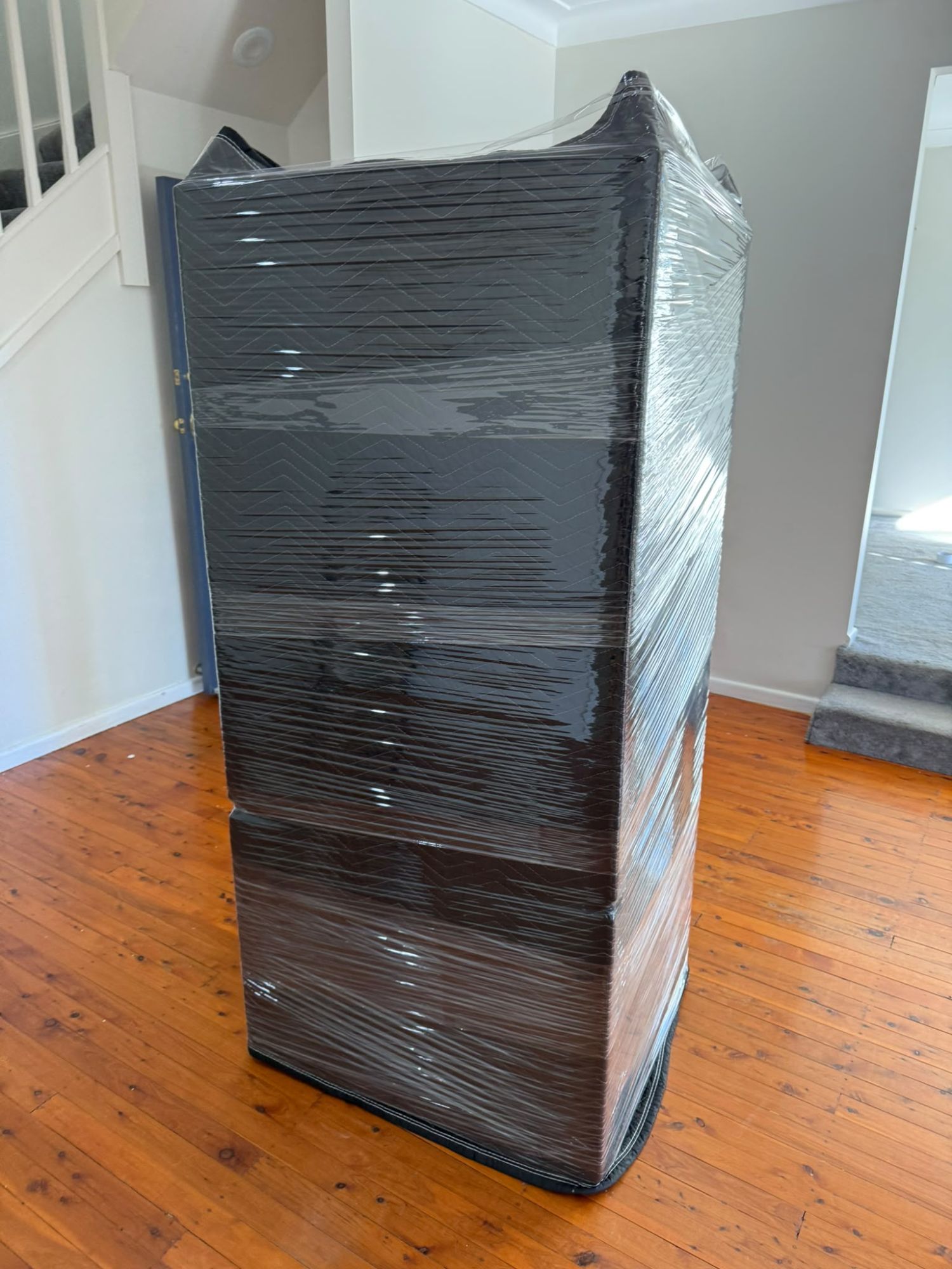 Wardrobe wrapped in moving blankets and shrink wrap by Sydney removalists