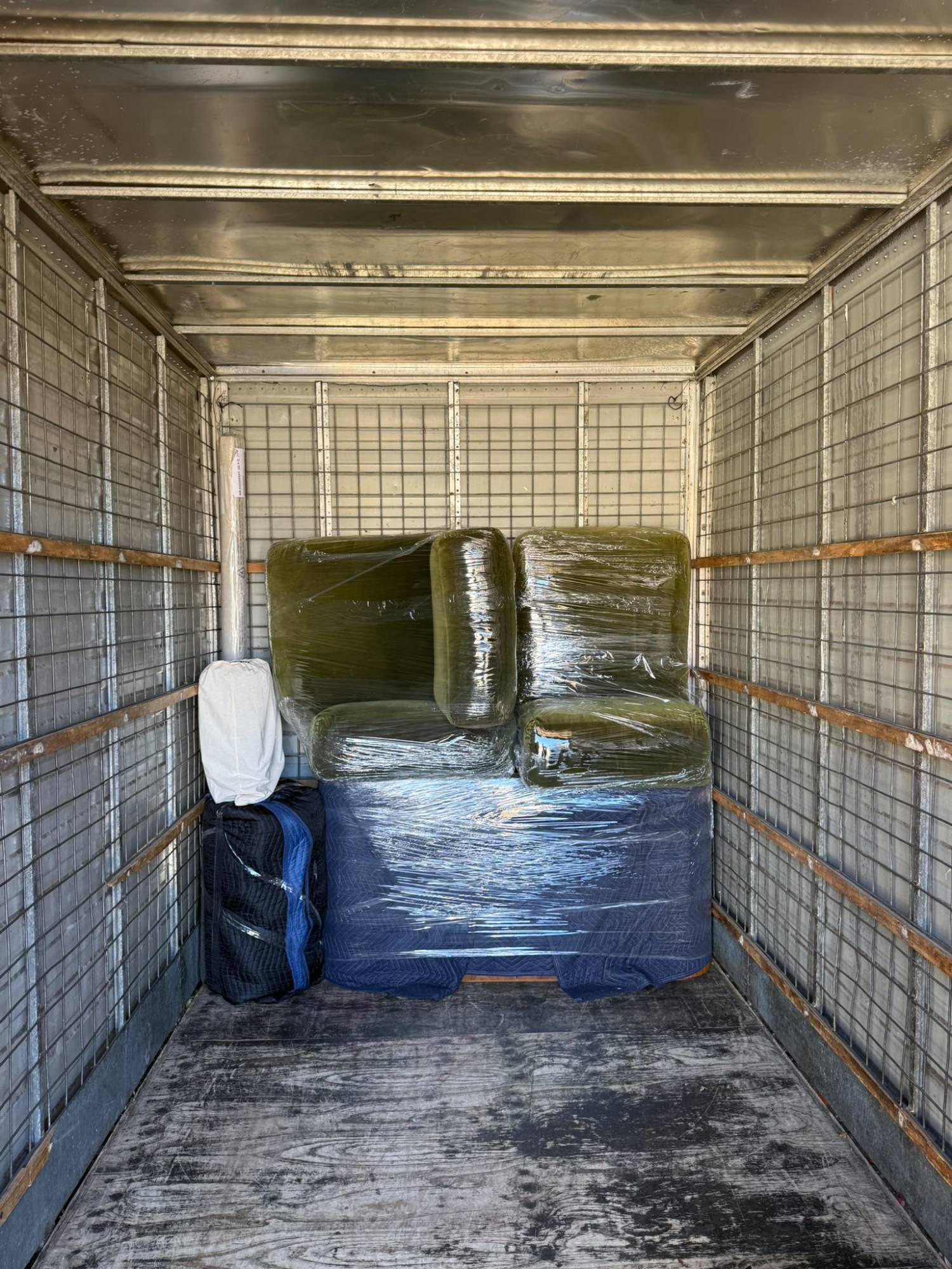 Wrapped sofa loaded and secured inside a removalist truck